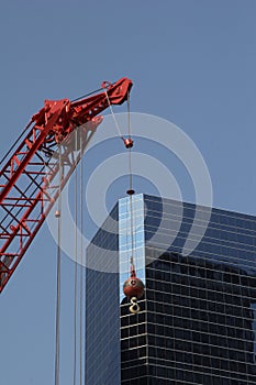 Red construction crane before a modern office building
