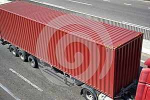 Red container and truck on road top view, cargo transportation and shipping concept