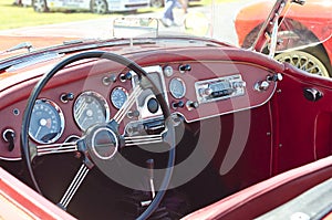 Red convertible vintage sports car with steering wheel and gauges