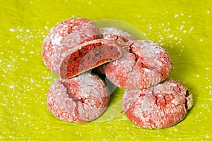 Red cookies with icing sugar isolated on green background