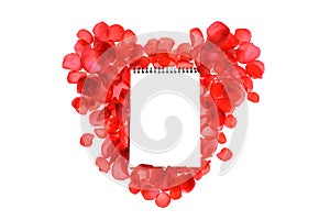 Red coral roses petals on heart shape and notebook isolated on white background.