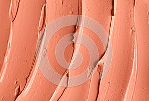 Red cosmetic clay alginate facial mask, face cream, body wrap texture close up, selective focus. Abstract background with brush