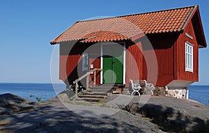 Red cottage by sea