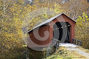 Red covered bridge in bright fall foliage