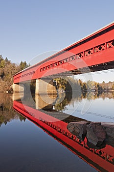 Red Covered Bridge with Reflection in Water photo