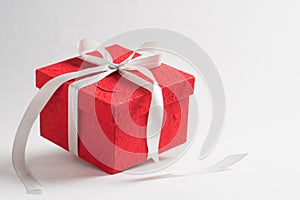 Red crafts present box tying by white ribbon isolated on blackground with copy space for text