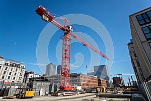 Red crane on construction site under blue sky