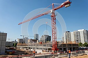 Red crane on construction site under blue sky