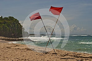 Red crossed flags on the beach mean a prohibition to swim