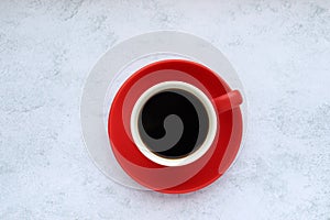 Red cup of black americano, espresso coffee on gray concrete background. Top view, copy space