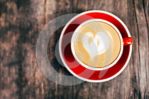 Red cup of cappucino with beautiful latte art