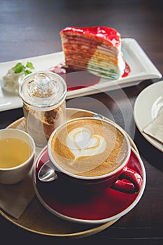 red cup coffee time and tasty cake on wood table in cafe restaurant.