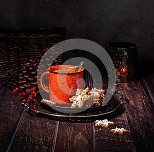 Red Cup of hot chocolate with Christmas cookies on a rustic wood table