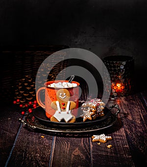 Red Cup of hot chocolate with Gingerbread Man Christmas cookie on a rustic wood table