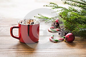 Red cup of hot chocolate with marshmallow on windowsill. Weekend concept. Home style. Christmas morning.