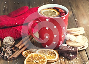 Red cup of hot tea with orange and berries Christmas winter beverage Christmas food concept Wooden background Cinnamone sticks Coo