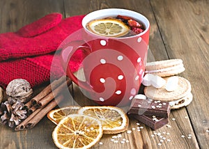 Red cup of hot tea with orange and berries Christmas winter beverage Christmas food concept Wooden background Cinnamone sticks Coo