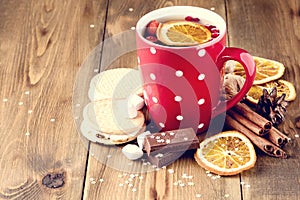 Red cup of hot tea with orange and berries Christmas winter beverage Christmas food concept Wooden background Cinnamone sticks Coo