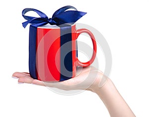 Red cup mug with blue ribbon bow gift in hand