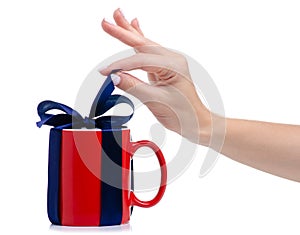 Red cup mug with blue ribbon bow gift in hand