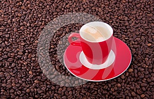 A red cup and saucer with coffee