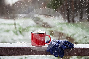 Red cup on a snow bridge in a winter park