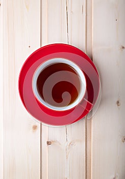 Red cup with tea on saucer