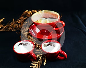 Red cups with coffee on black background