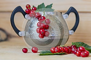 Red currants in a beautiful vintage rare can. Rural still life. Natural organic food production. Heap of summer red berries.