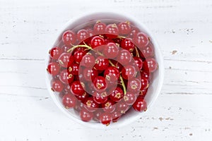 Red currants berries from above bowl wooden board