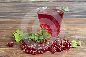 Red currants and green leaves on a dark background. Vitamin cocktail