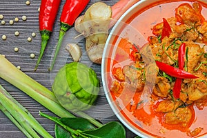 Red curry chicken, Thai Spicy food and fresh herb ingredients on wooden top view / still life, selective focus