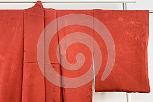 red curtain on the clothes rack in the room, closeup of photo