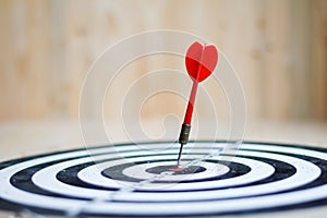 Red dart arrow hit the center target of dartboard metaphor marketing competition concept