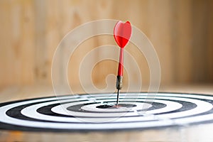 Red dart arrow hit the center target of dartboard metaphor marketing competition concept