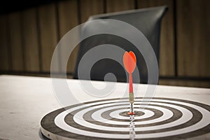 Red dart arrow hitting in the target center of dartboard on bullseye with sun light vintage style, Target marketing and business s