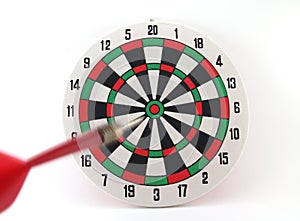 red dart arrow moving straight to goal in bullseye of colorful dartboard isolated on white background