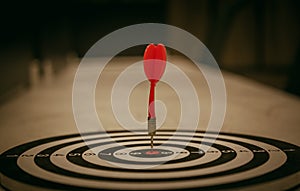 Red dart target arrow hitting on bullseye
