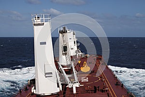 Red deck large bulk carrier on background of ocean