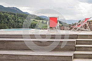 Red deckchair at the edge of an outdoor hydromassage pool, Italy