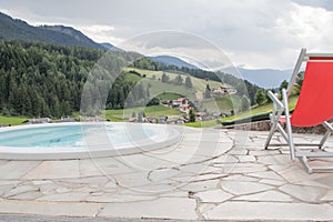 Red deckchair at the edge of an outdoor hydromassage pool, Italy