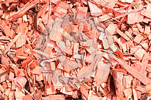 Red decorative chips, wood textured background top view. Shredded tree bark for decorating a garden plot and other surfaces