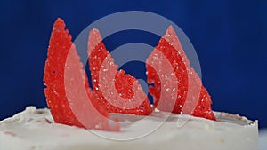 Red decorative element on the cake. Marmalade on the cake. Slice of strawberry cake