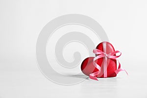 Red decorative heart with ribbon and bow knot on table