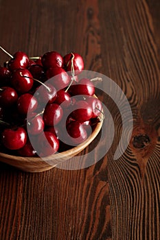 Red delicious cherries in wooden bowl