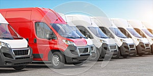 Red delivery van in a row of white vans. Best express delivery and shipemt service concept