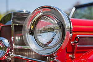 Red detail on the headlight of a vintage car