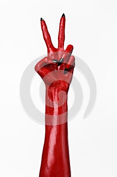 Red Devil's hands with black nails, red hands of Satan, Halloween theme, on a white background, isolated