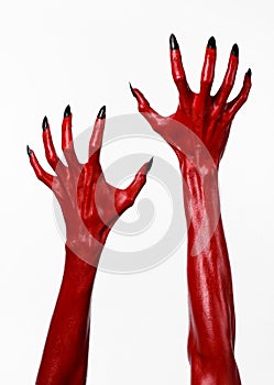 Red Devil's hands with black nails, red hands of Satan, Halloween theme, on a white background, isolated