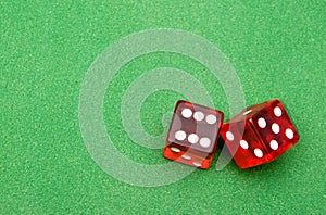 Red dice against green background